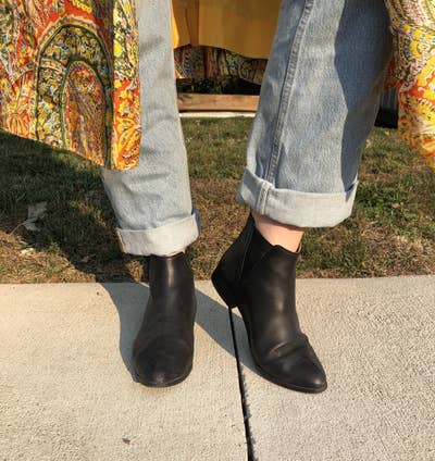 writer wearing black leather boots with elastic cutouts on the sides and a pointed toe