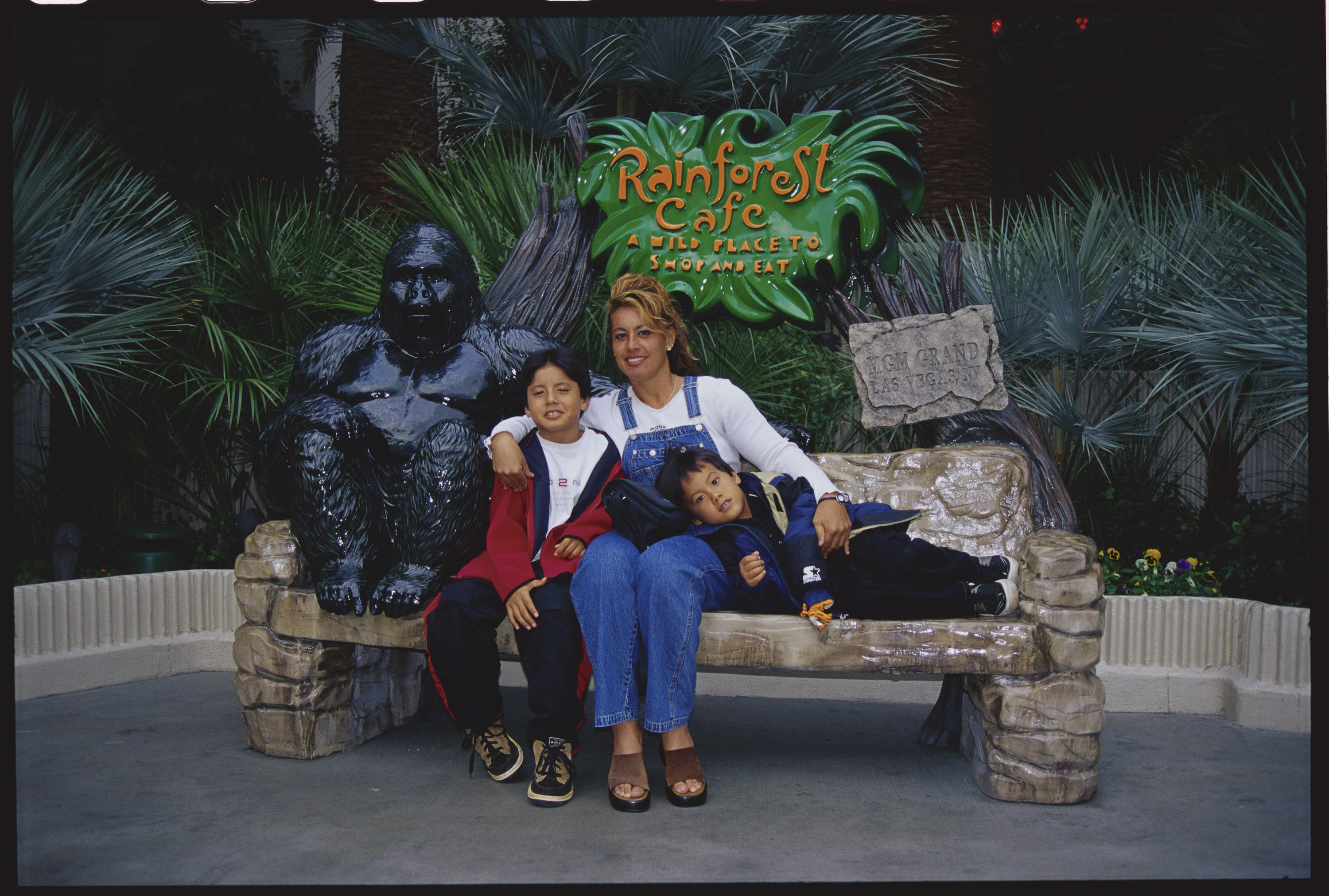 A mom with her two sons posing outside a Rainforest Cafe 