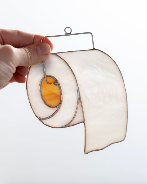Small stained glass designed to look like unrolled toilet paper 
