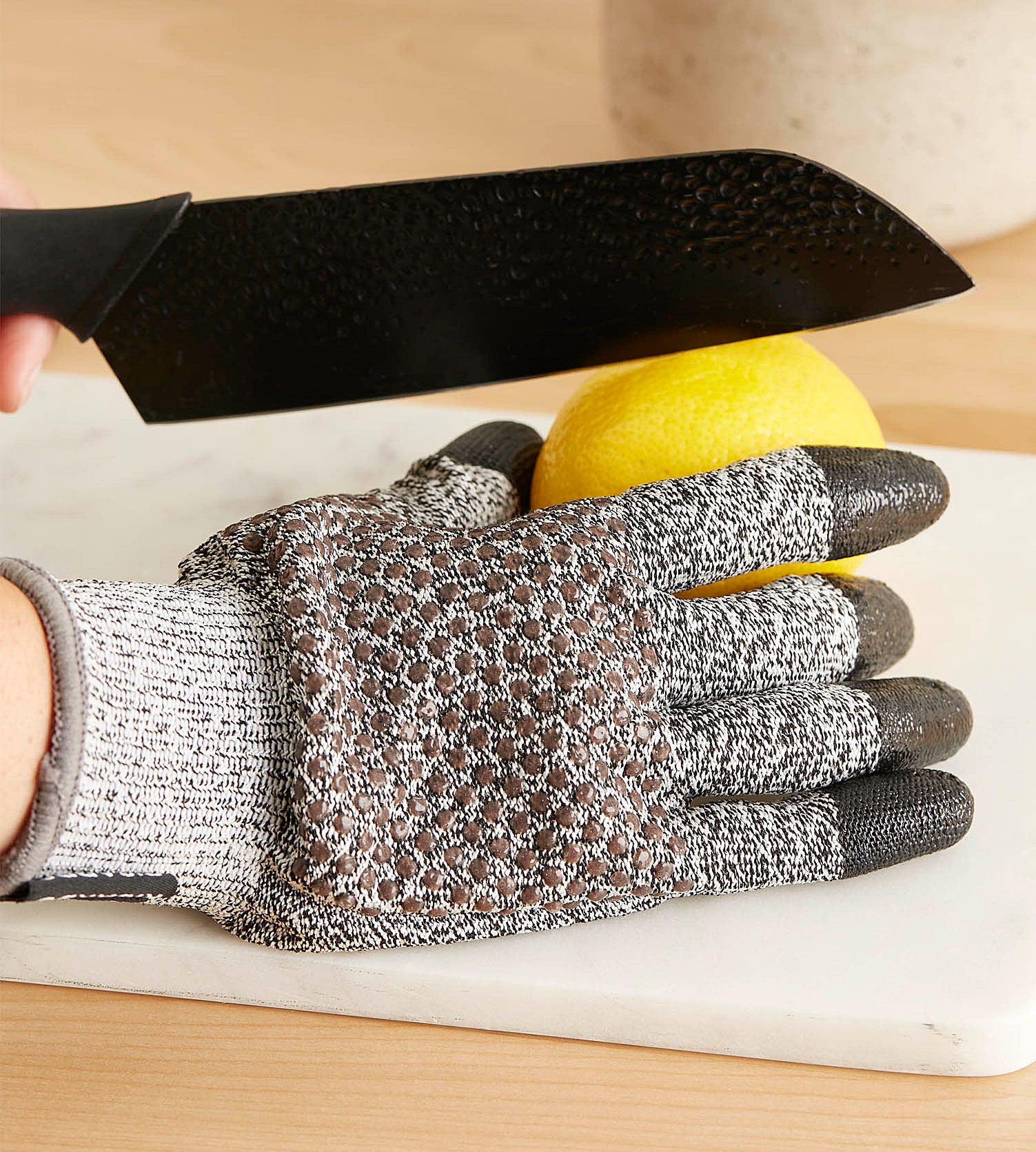 A person wearing the glove and cutting a lemon