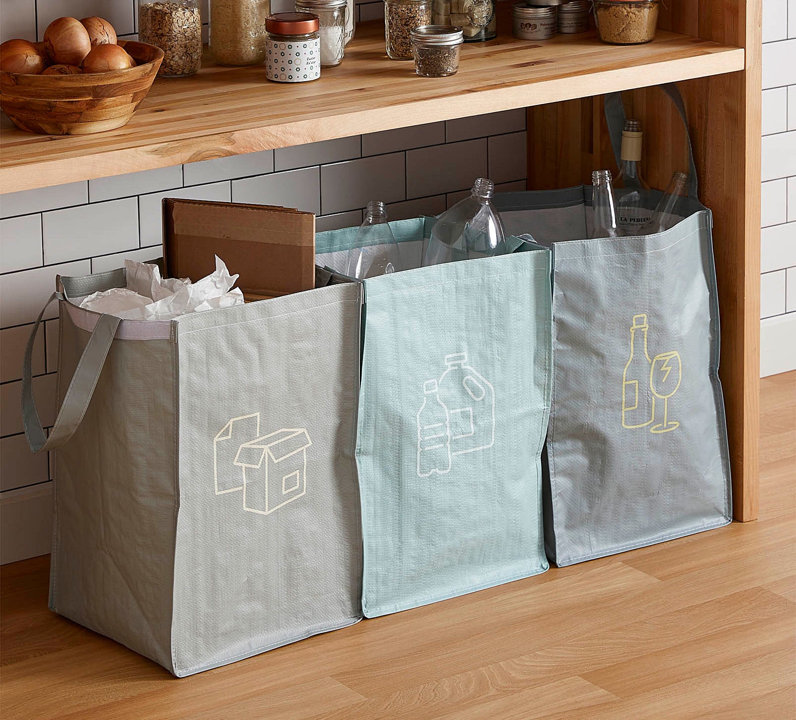 Three recycling bags under a counter