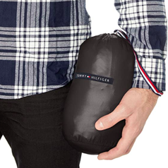 model holding packable puffer in its carrying bag 