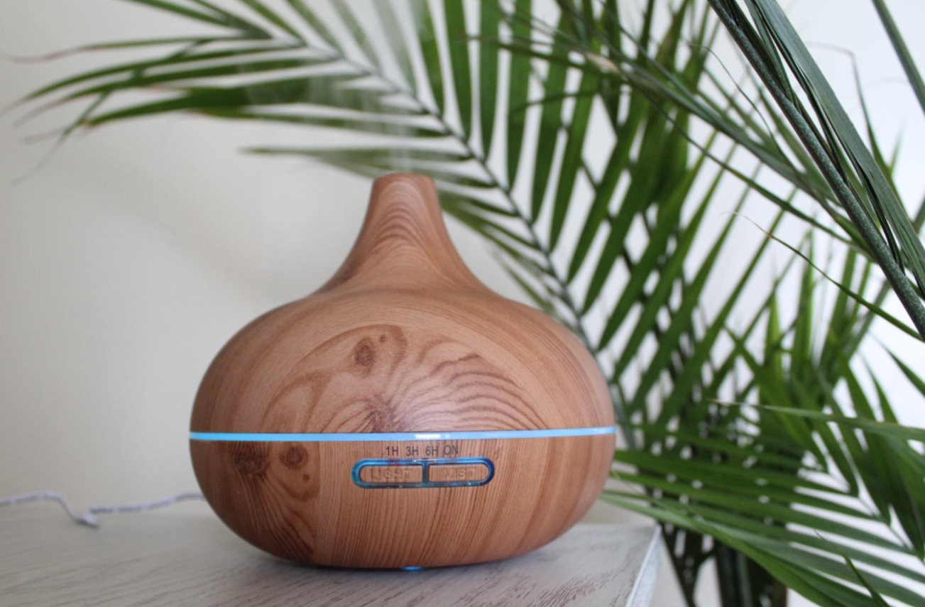 A reviewer&#x27;s photo of the diffuser with blue light settings and two buttons