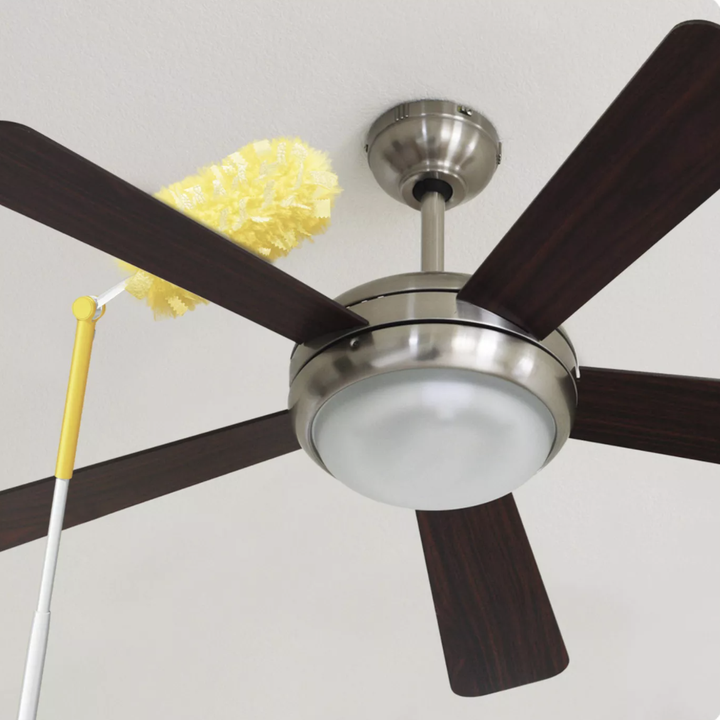 ceiling fan being cleaned with yellow duster 