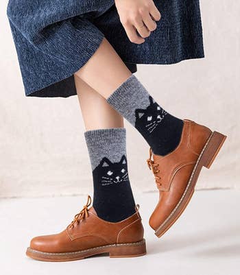 A model wearing the grey socks with black cats peeking out of Oxfords