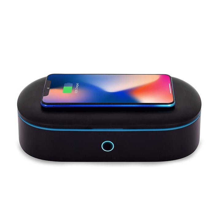 The box with a mobile phone atop it, charging.