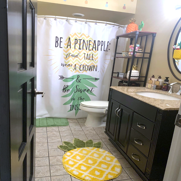 the rug in a bathroom that also has a pineapple shower curtain