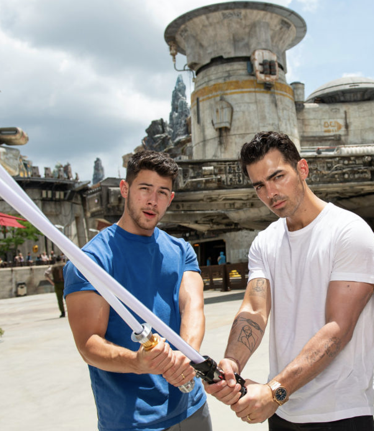 Joe and Nick holding lightsabers at the Star Wars part of Disney World