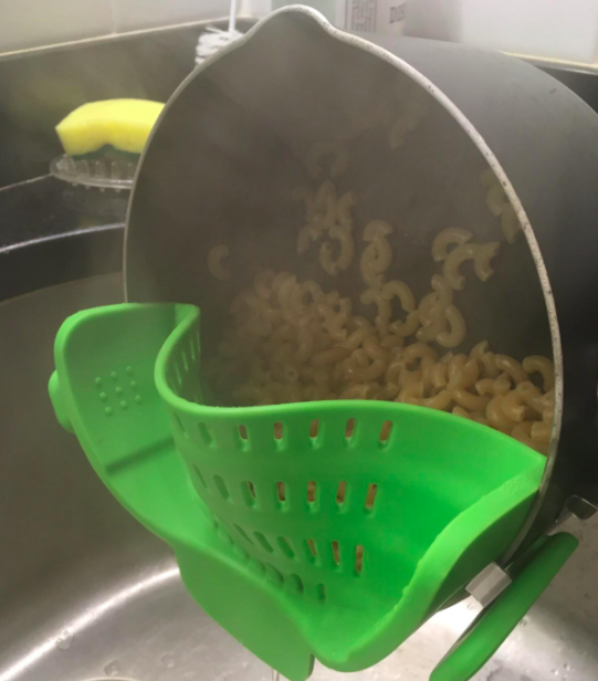 reviewer photo showing the snap-n-strain in use with a pot of boiled pasta being strained into a sink 