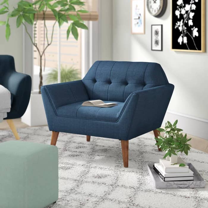 The tufted armchair in blue with wooden legs