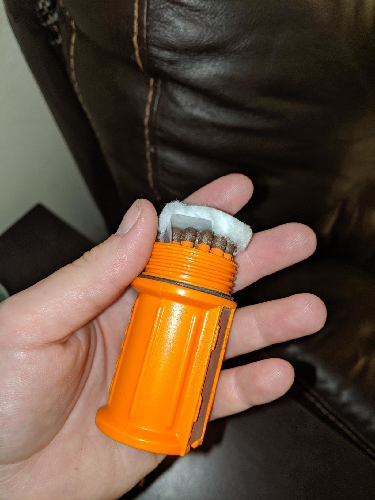 A customer holds his orange UCO Stormproof Match Kit with Waterproof Case