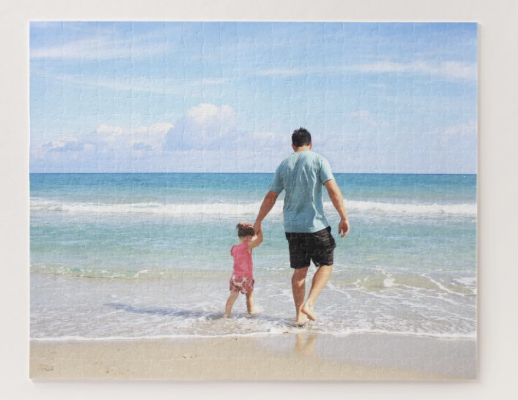 A pic of an adult and child on a beach in puzzle form 