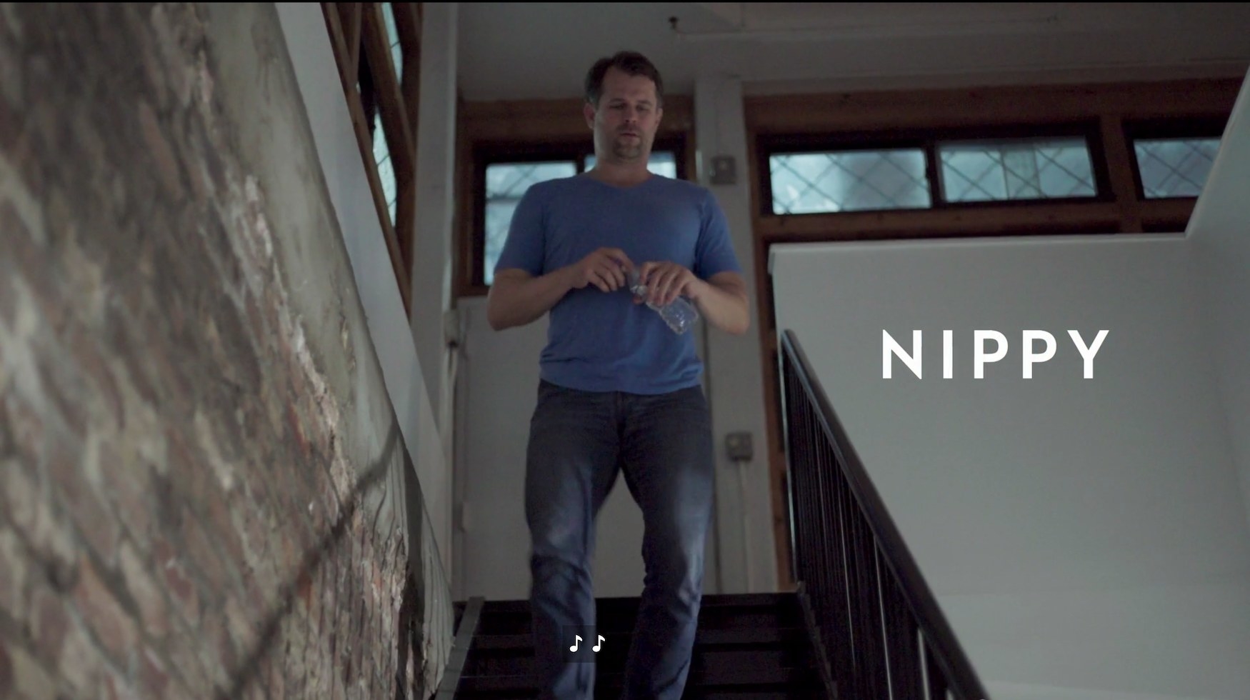 A screenshot of a man in walking downstairs with a title card identifying him as Nippy