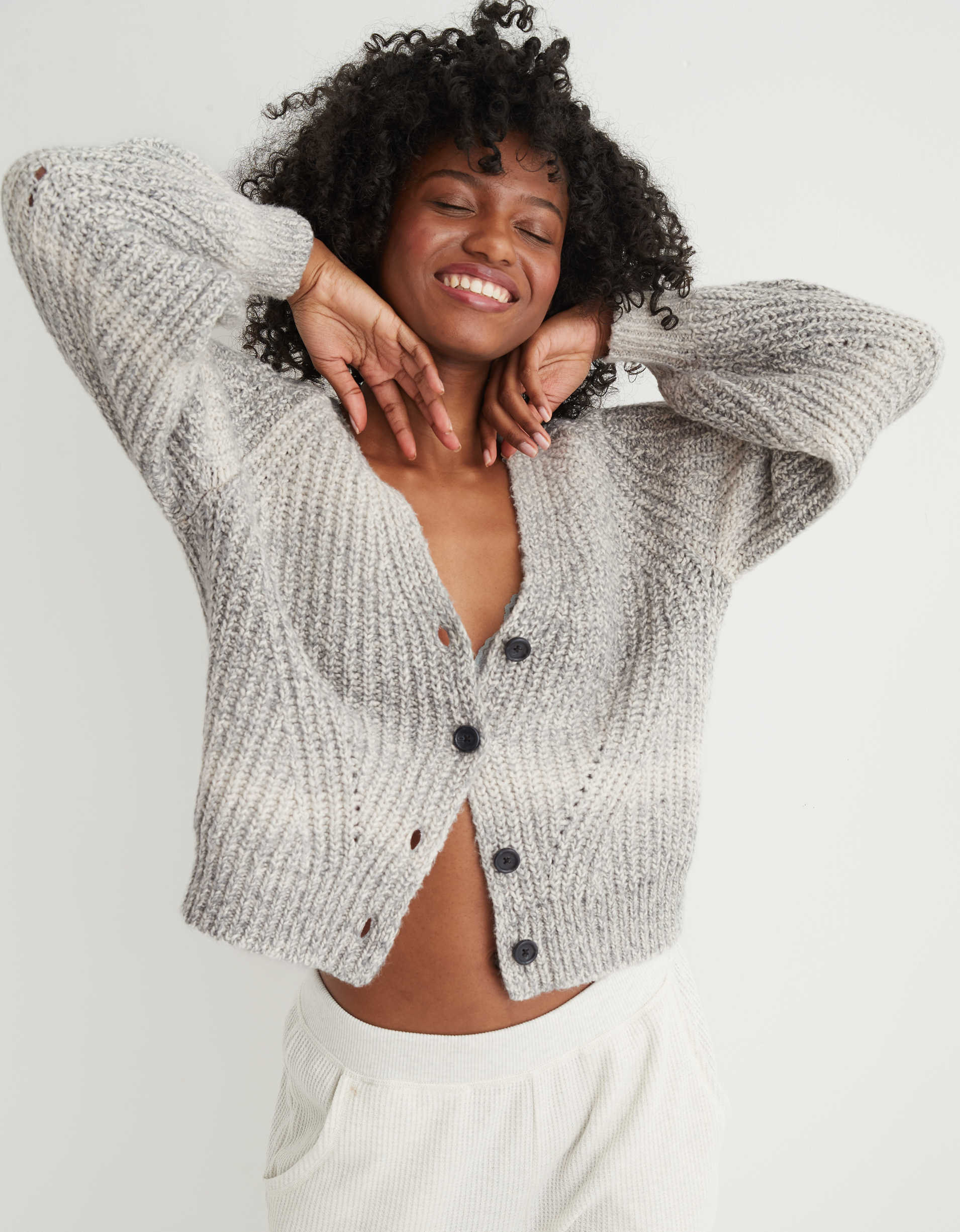 Model wearing the knitted cardigan with an ombre pattern on it and black buttons