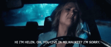 A gif of Kristen Wiig in Bridesmaids sitting in her car crying and saying hi I&#x27;m Helen oh you live in Milawukee I&#x27;m sorry