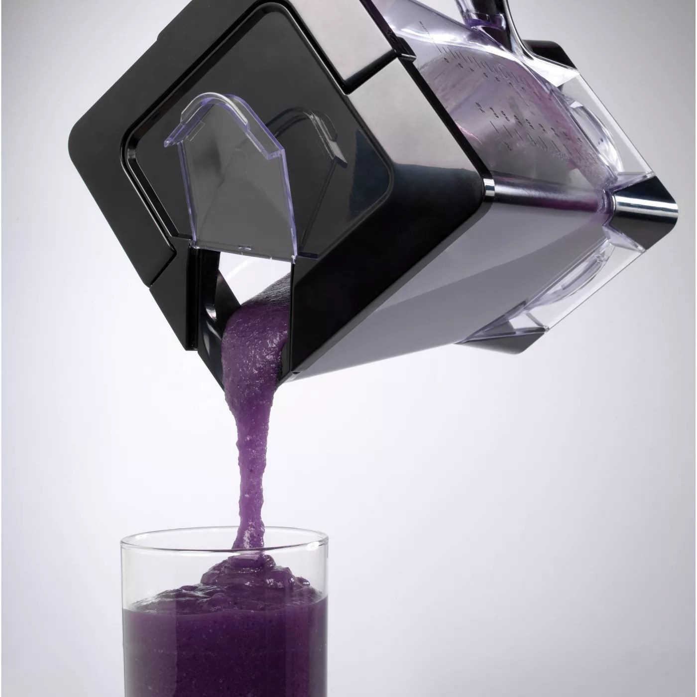 A model pouring a smoothie from the blender into a glass