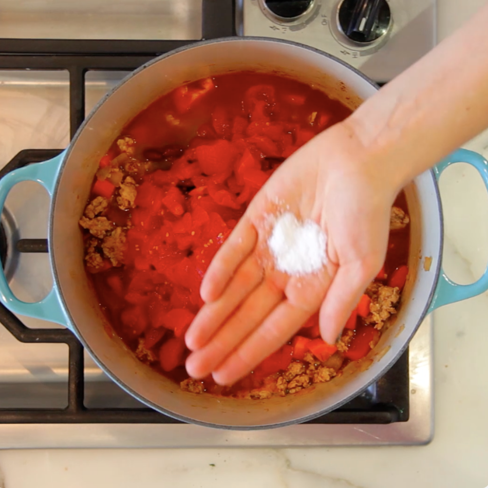 A chef putting salt into their hand