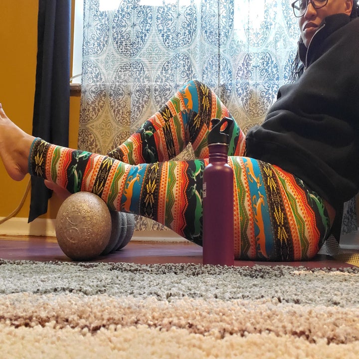 BuzzFeed writer laying on a yoga mat with her purple klean kanteen bottle nearby
