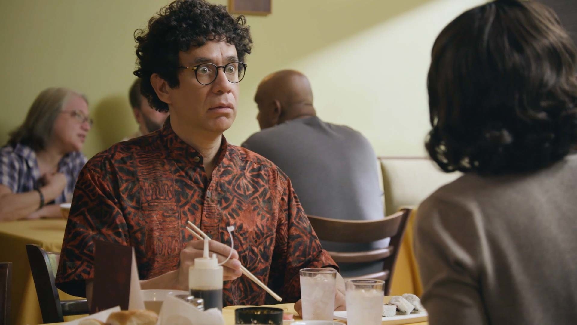 Fred Armisen in Portlandia eating dinner with circular glasses on looking horrified 