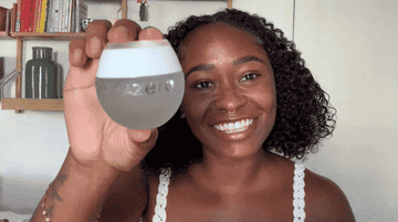 A gif of one of the testers holding the jar of the no pigment foundation.