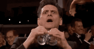 Actor Jim Carrey at the Golden Globes, using cups as glasses as if trying to see something