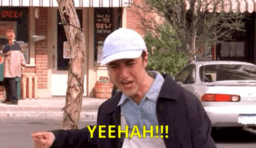 A gif from Gilmore Girls shows a Kirk a man in a hat addressing a group of people in the centre of town and saying yeehaw