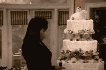 Lisa bites the head off of the groom figurine atop her wedding cake