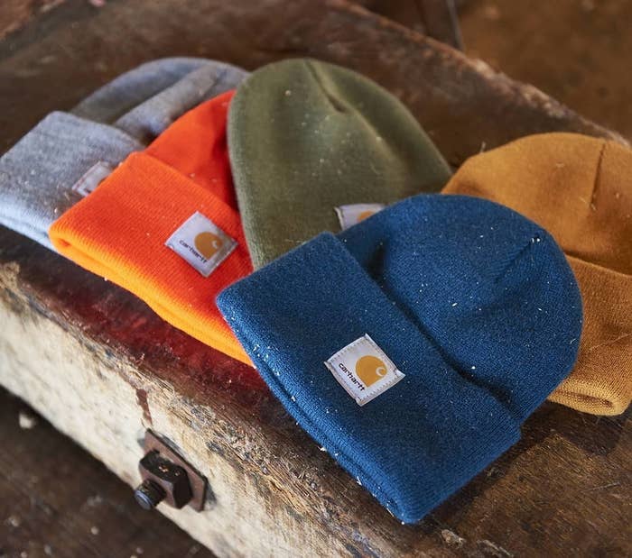 Five beanies on a wooden bench