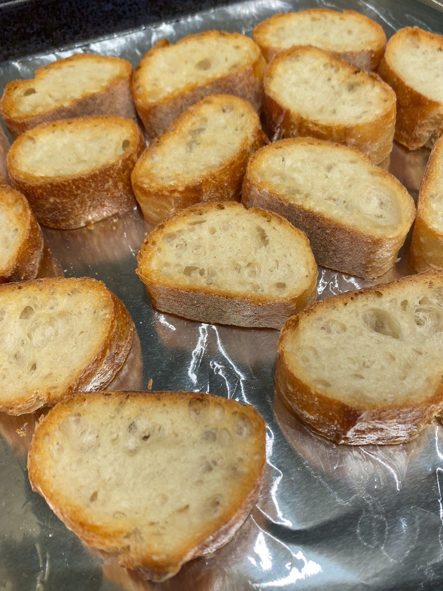 Slices of toasted bread on a baking sheet.