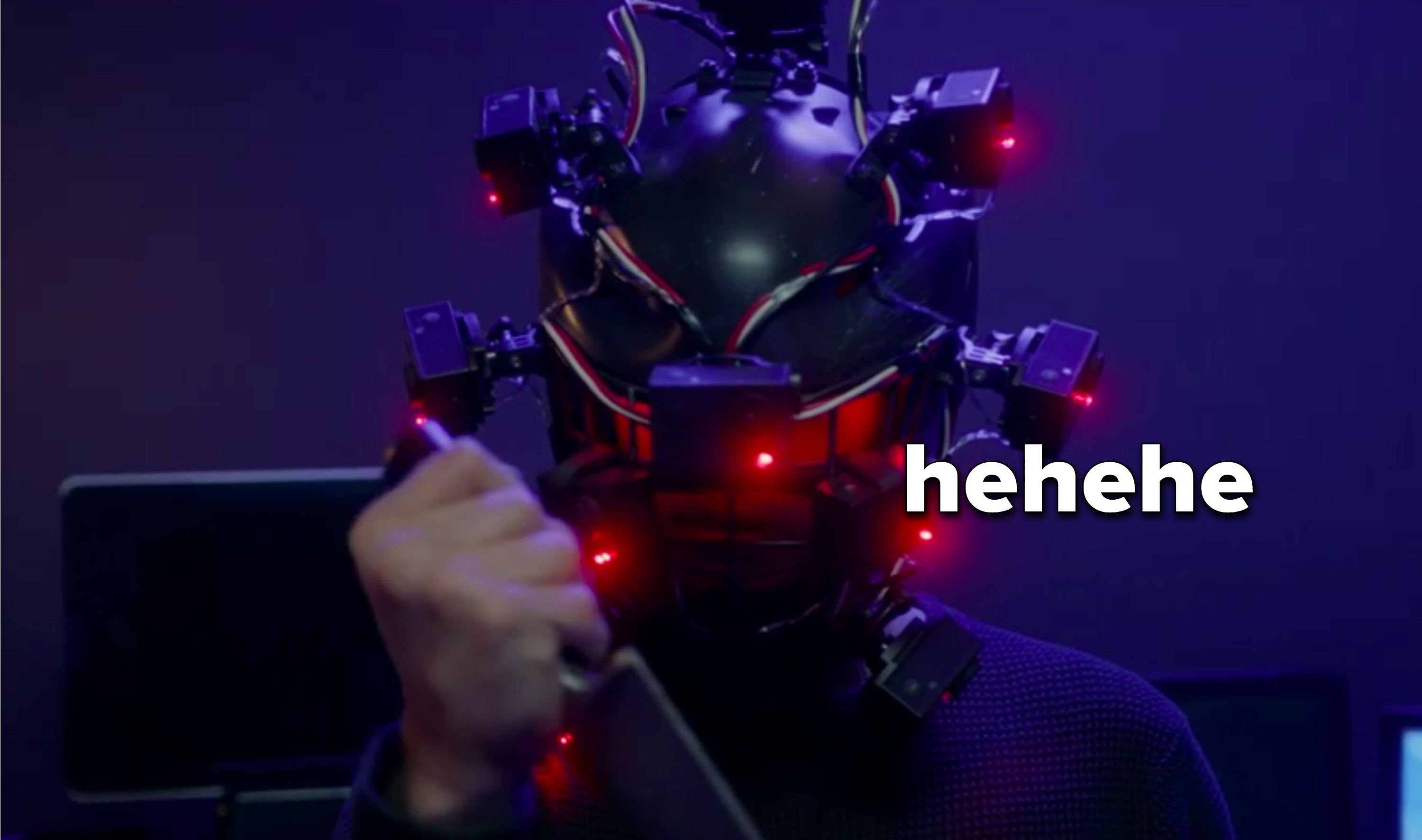 Brad wielding knife while wearing giant scary VR helmet, captioned, &quot;hehehe&quot;