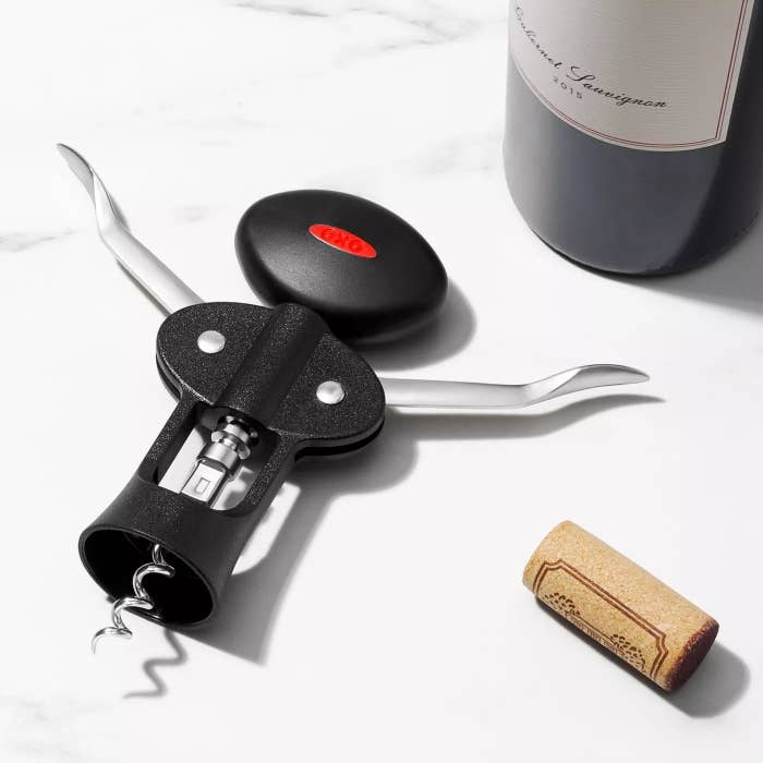 The corkscrew next to a bottle of wine on a countertop