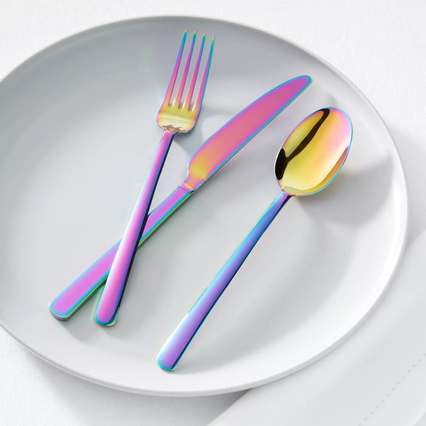 A fork, knife and spoon from the rainbow flatware set on a plate