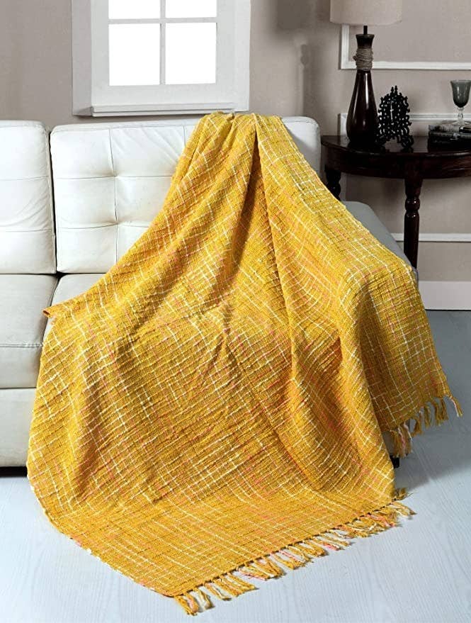 Yellow throw blanket on a white couch.