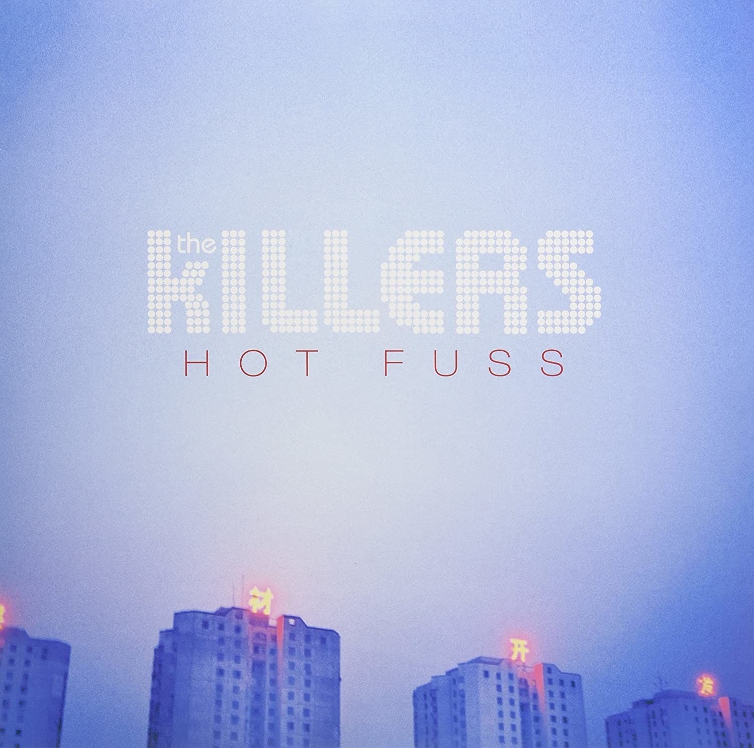 album cover of The Killers&#x27; Hot Fuss showing a hazy blue sky over high-rise buildings.