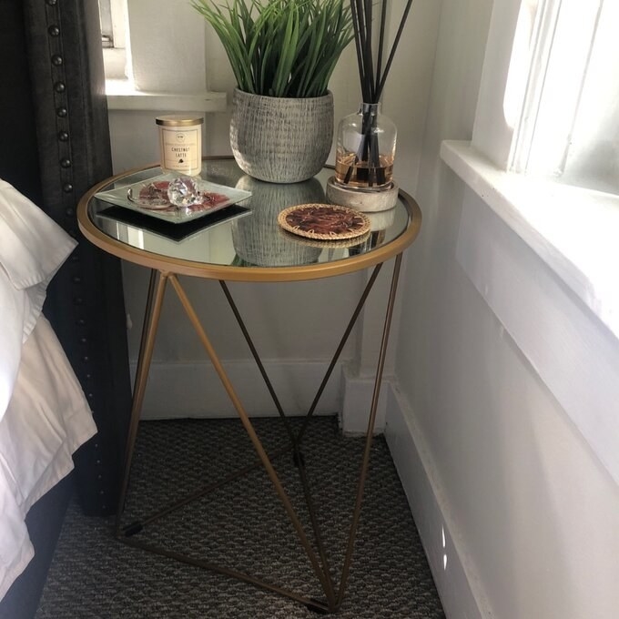 Reviewer's picture of the side table with gold metal legs in a triangular design with white surface