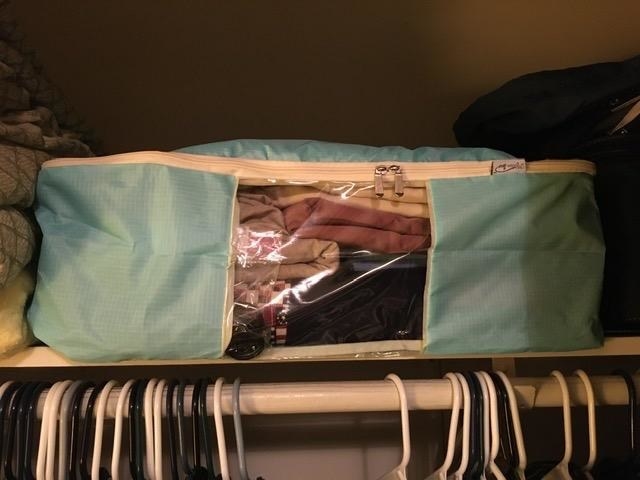 The turqouise Madam Sew Large Quilt Storage Bag storing blankets in a customer&#x27;s closet
