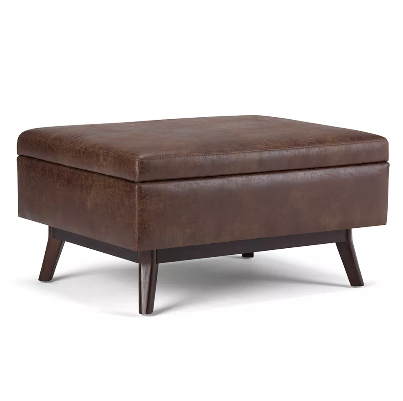 A brown leather coffee table storage ottoman with dark wooden legs