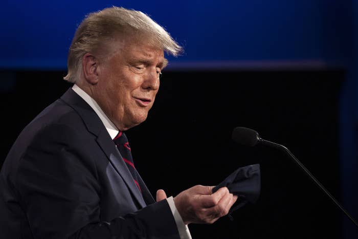 President Trump looks at his mask.