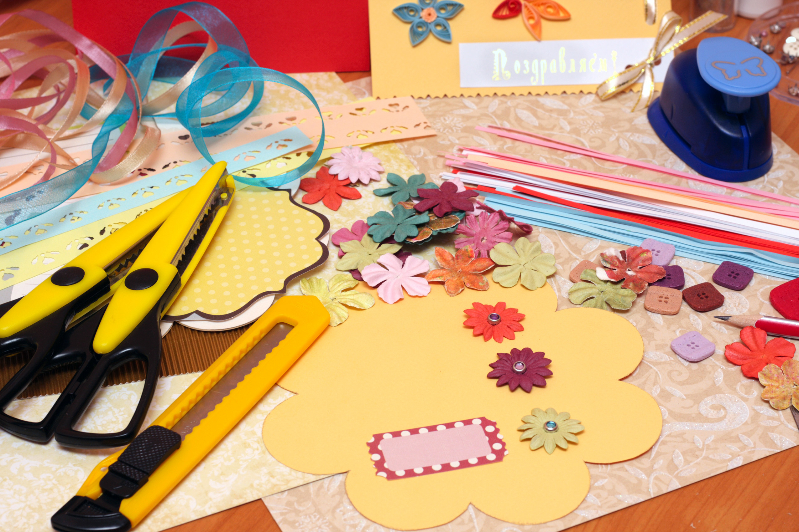 photo of a diy arts and craft table with paper shaped like flowers and accessories to be added to the paper shaped like a flower