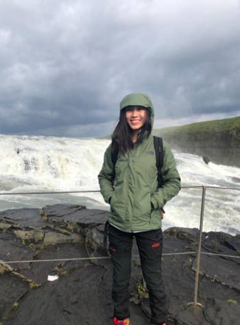 Reviewer wears pair of black windproof pants while visiting a waterfall in Iceland