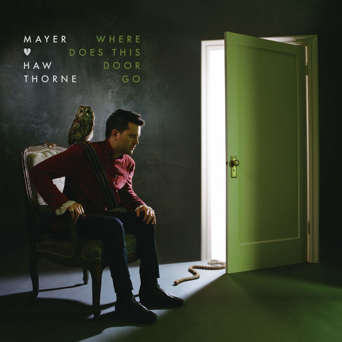 Mayer Hawthorne sitting in front of an open door. 