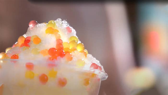 Close up of an icy drink topped with multiple, little rainbow bursties