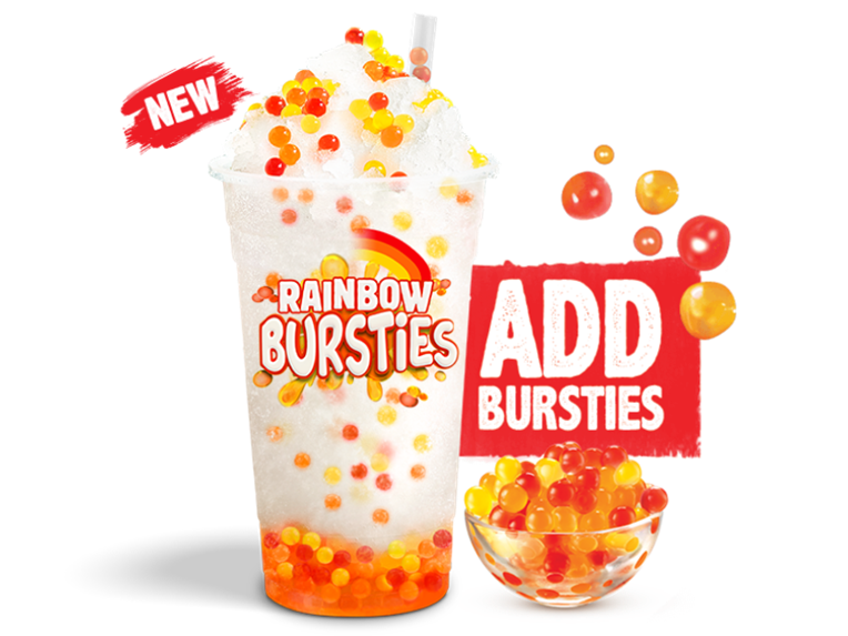 An icy drink filled with rainbow bursties and a little bowl filled with bursties on one side