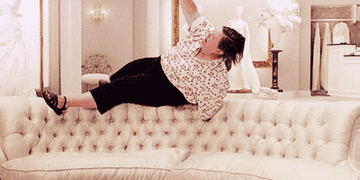 Woman falling onto sofa exhaustedly.