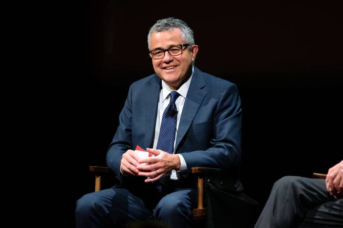 Jeffrey Toobin holding cue cards at an on-stage event.