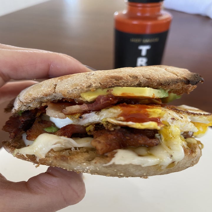 A breakfast sandwich topped with Truff hot sauce.