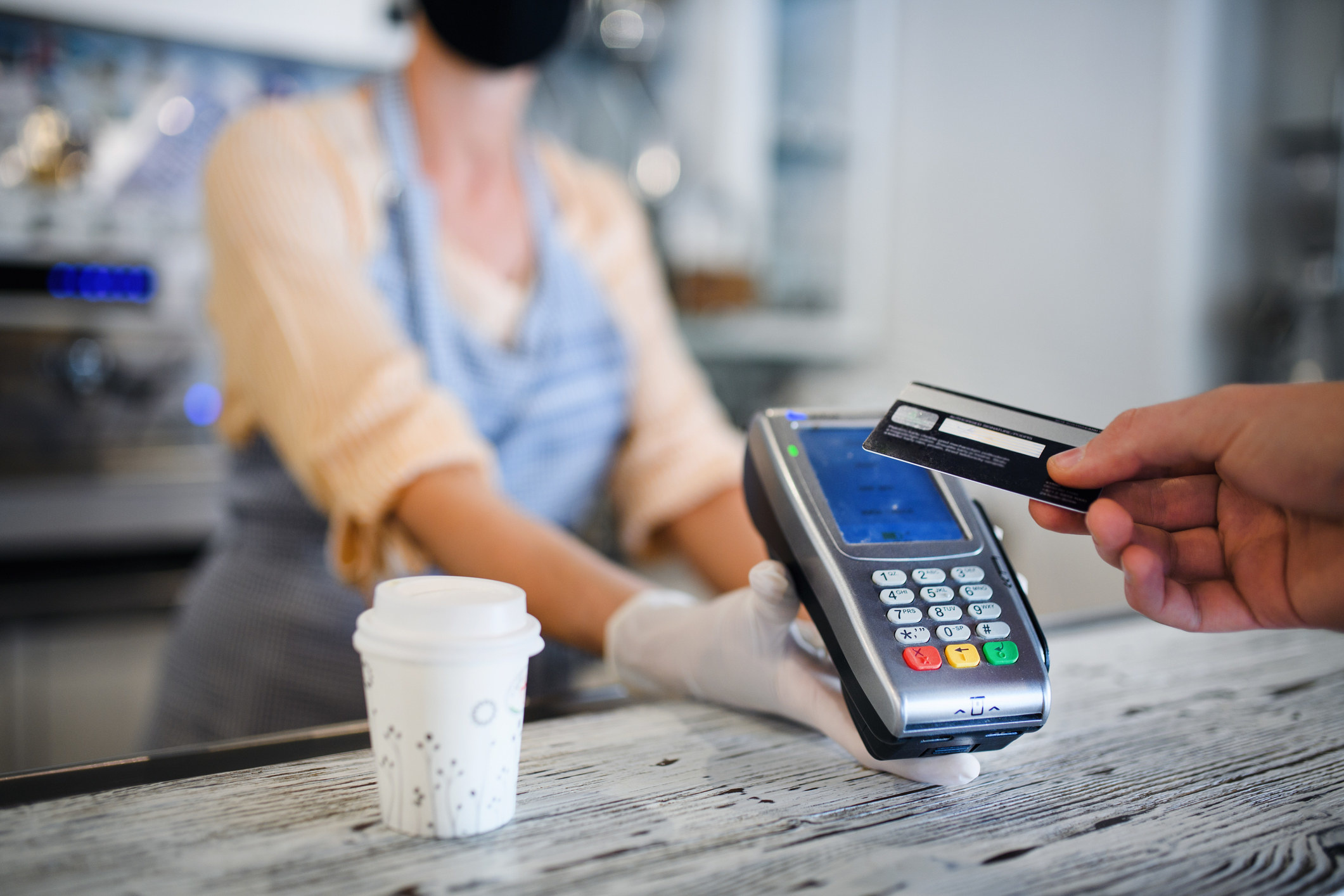 A person paying for coffee with a card