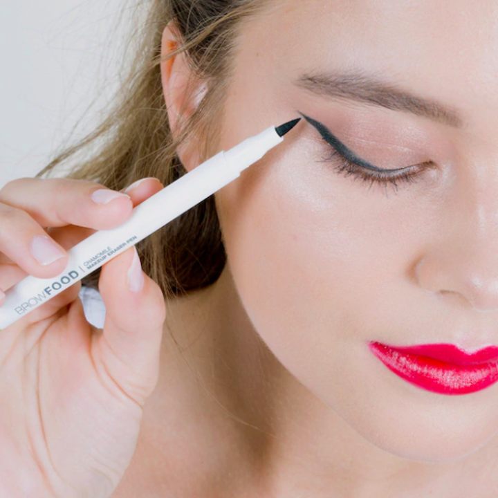 A close up of a person using the makeup-erasing pen to touch up their eyeliner