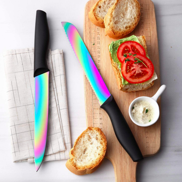 Iridescent rainbow knives with black handles next to cutting board with bread slices