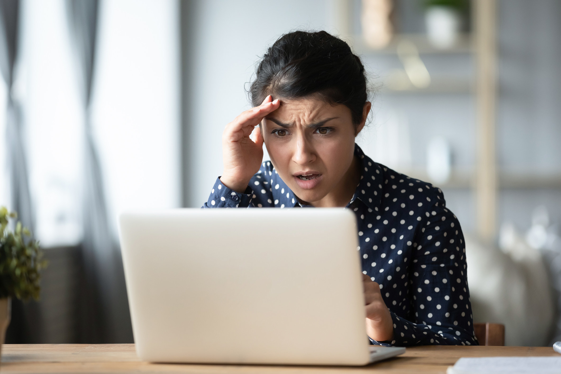 A woman shocked staring at a computer